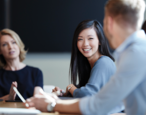 Young female professional smiling during group discussion