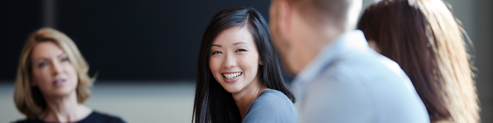Young female professional smiling during group discussion