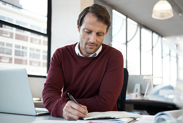 businessman taking notes on virtual learning content