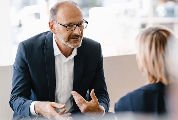 Businessman and woman having a meeting in a coffee shop, discussing work
