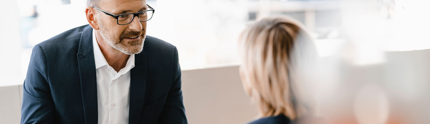 Businessman and woman having a meeting in a coffee shop, discussing work
