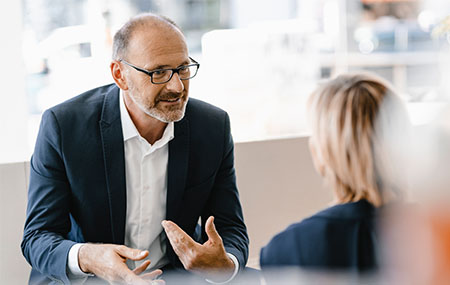Businessman and woman having a meeting in a coffee shop, discussing work