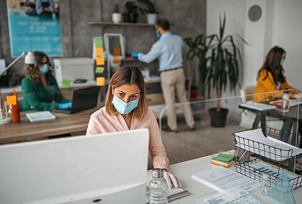 Business colleagues working at office by maintaining social distance