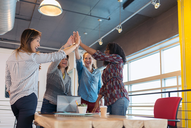 Businesswomen high fiving in conference room