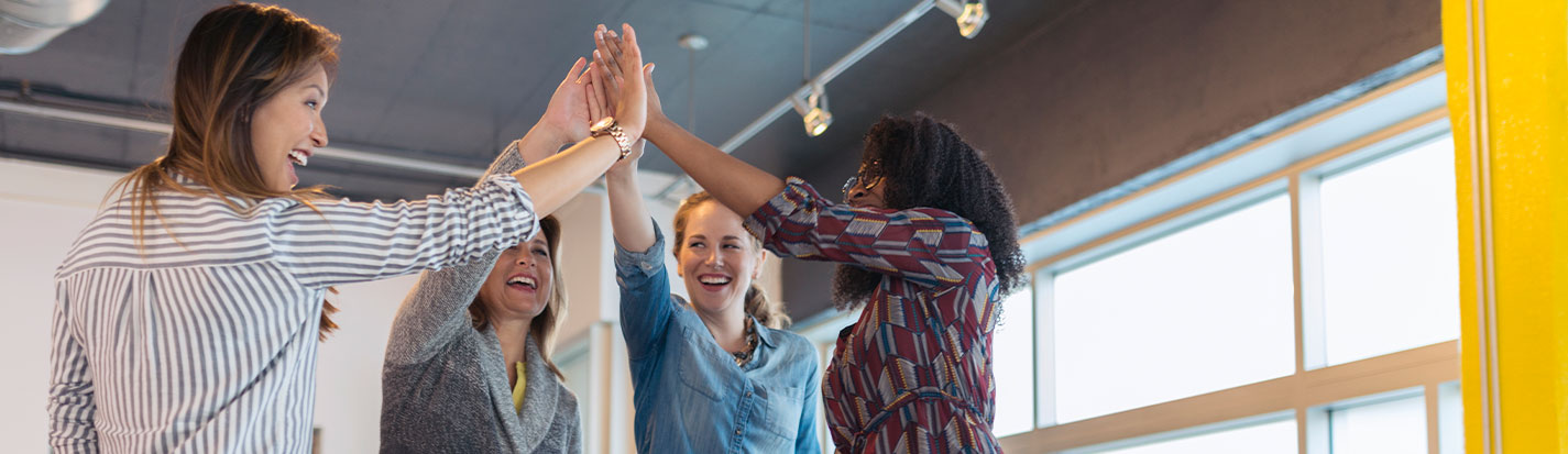 Businesswomen high fiving in conference room