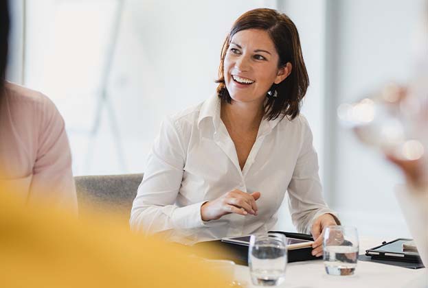 Cheerful mid adult woman smiling at business meeting