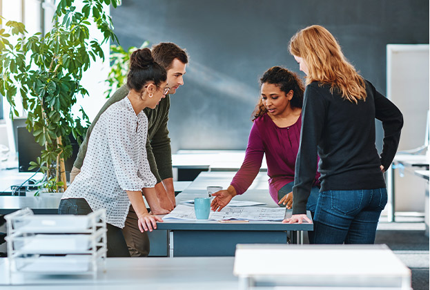 a group of coworkers having a performance management discussion around a table