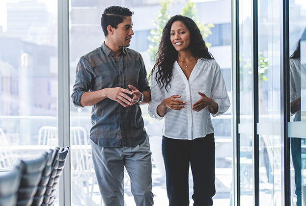 Businessman and businesswoman walking and talking