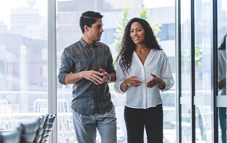 Businessman and businesswoman walking and talking